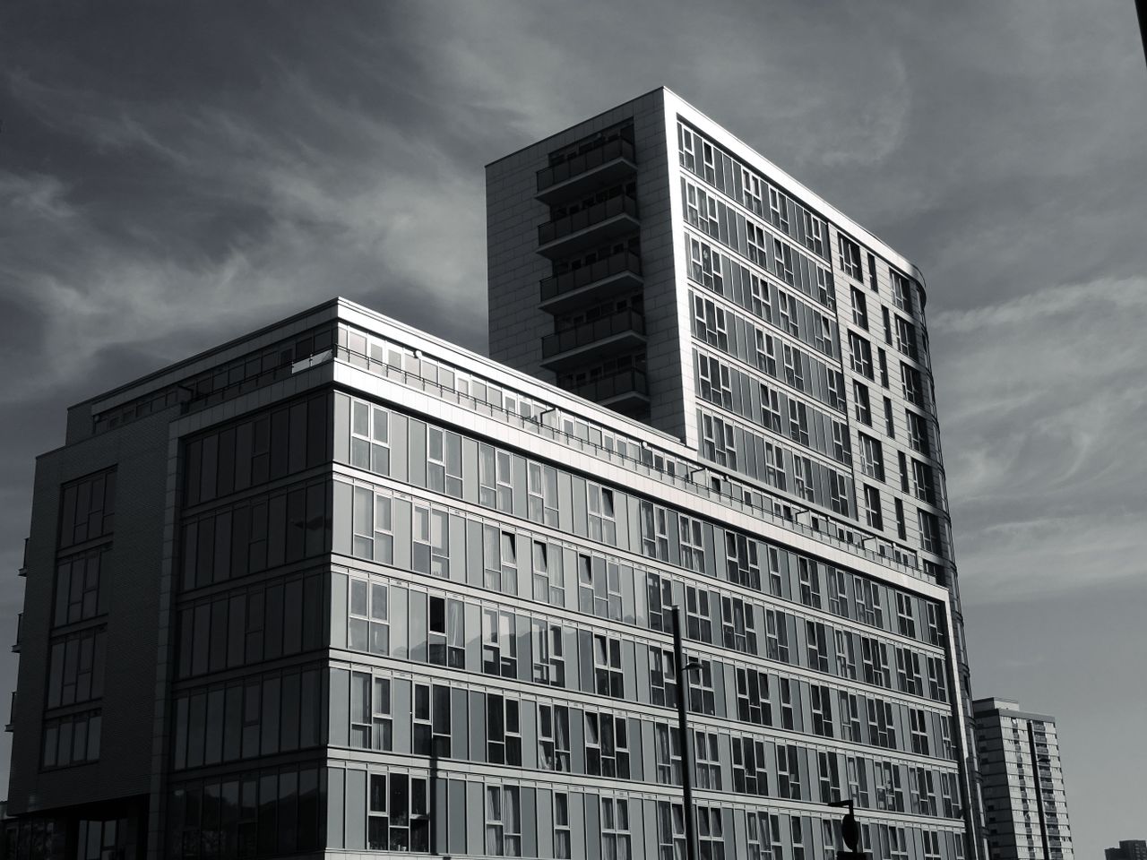 A modern building with glass windows and steel elements showcasing contemporary architectural design.